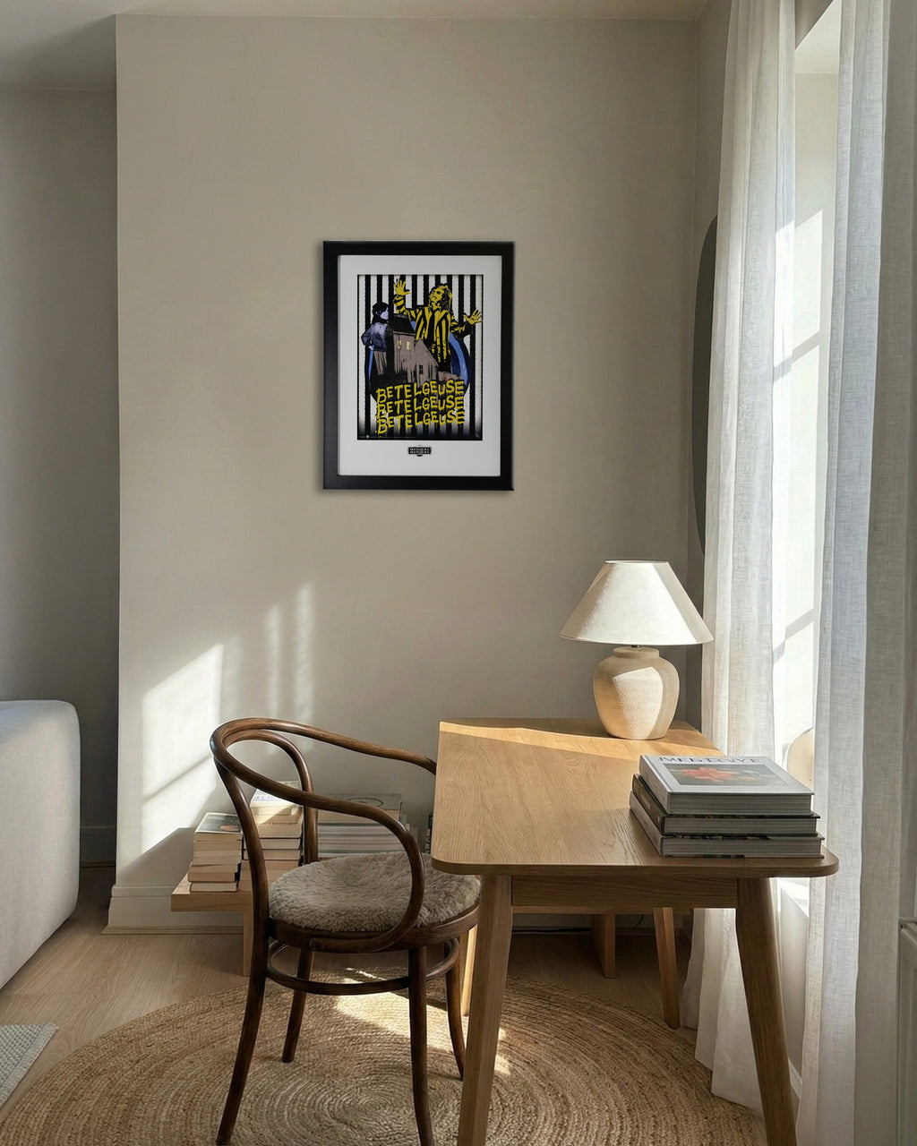 Plakat Beetlejuice w czarnej ramie na ścianie – aranżacja wnętrza salonu z drewnianym biurkiem