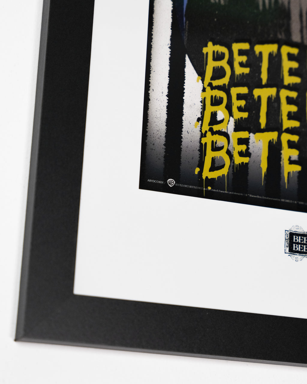 Zbliżenie plakatu Beetlejuice w czarnej ramie – detal ramki i passe-partout