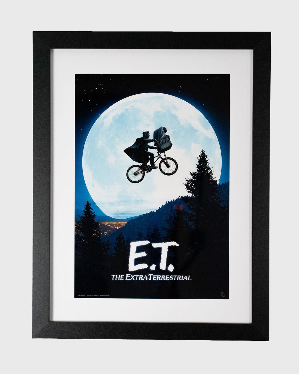 Plakat filmowy E.T. – The Extra-Terrestrial w czarnej ramie z białym passe-partout