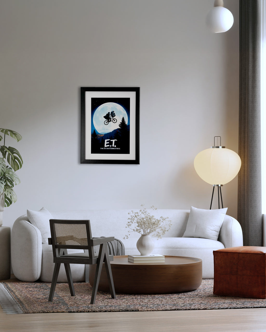 Plakat filmowy E.T. – The Extra-Terrestrial w czarnej ramie na ścianie w nowoczesnym salonie