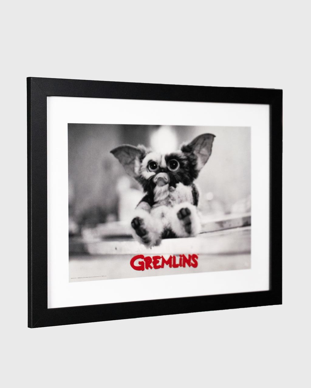 Plakat Gremlins z Gizmo w czarnej ramie – filmowy plakat Gremlins widok pod kątem