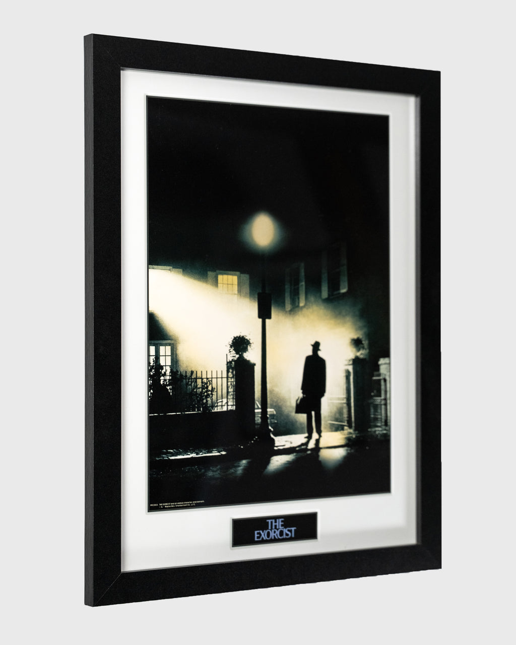 Plakat filmu The Exorcist w ramie z białym passe-partout, widok boczny
